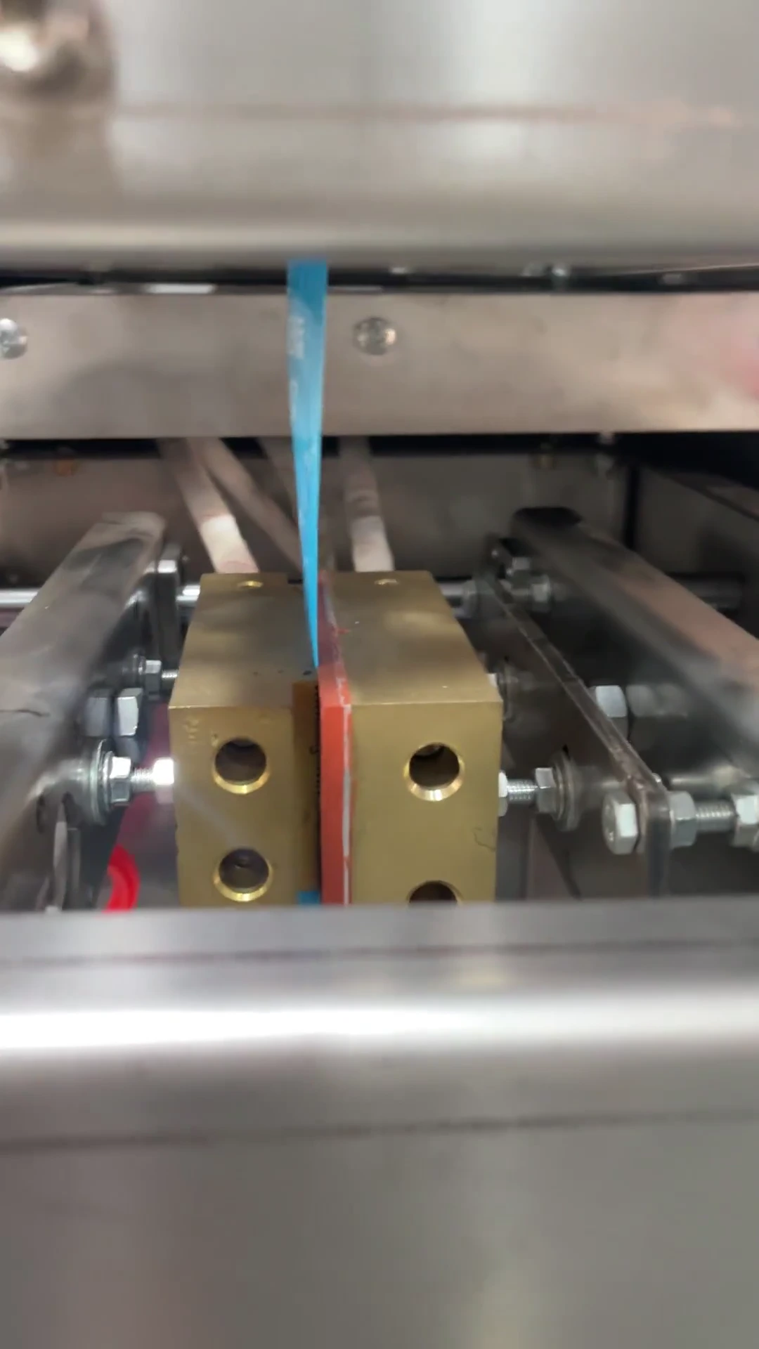 Automatic vertical form fill seal four-side seal liquid sachet packaging machine with sealed liquid pouches in modern manufacturing facility